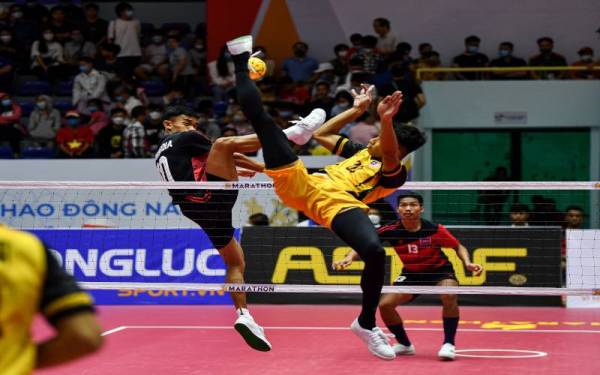 Pemain sepak takraw kebangsaan, Muhammad Redwan Hakim (kanan) melakukan rejaman ketika menentang pasukan Kemboja pada saingan liga sepusingan acara regu berpasukan sepak takraw lelaki sempena temasya Sukan SEA 2021 di Pusat Sukan Hoang Mai pada Sabtu. - Foto Bernama