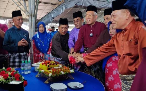 Mahdzir (empat dari kanan) memotong pulut kuning pada Majlis Aidilfitri Parlimen Padang Terap di Pusat Komuniti Padang Kerasak, Naka pada Sabtu.