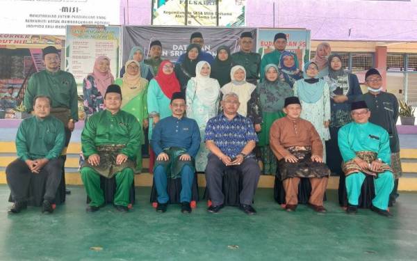 Noh (tiga dari kanan) bergambar bersama guru dan wakil ibu bapa pada Mesyuarat Agung Tahunan PIBG dan Pelancaran Program Unified Digital Library di Dewan SK Sungai Burung pada Sabtu.