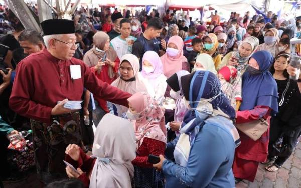 Mahdzir (kiri) menyampaikan duit raya kepada kanak-kanak ketika Majlis Sambutan Aidilfitri Peringkat Parlimen Padang Terap di Pusat Khidmat Komuniti Padang Kerasak, Naka pada Sabtu.