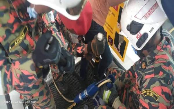 Anggota bomba berusaha memgeluarkan kaki mangsa yang tersepit di sebuah pusat membeli-belah di Alor Setar pada Sabtu. - Foto Bomba Alor Setar