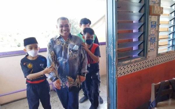 Dua murid Tahun 4 SK Kelulut bersama Ahmad Shahrul ketika memimpin guru berkenaan menuju ke kelas.