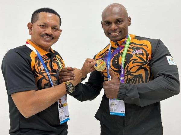 Mohd Syarul Azman (kanan) bergambar bersama Nur Azmi selepas dinobatkan selaku pemenang pingat emas dalam acara Men’s Athletic Physique Open di Pusat Latihan dan Pertandingan Sukan Hanoi pada Ahad. - Foto FB OCM