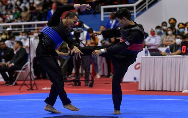 Aksi Muhammad Khairi Adib (kanan) ketika berdepan pesilat Indonesia Khoirudin Mustakim dalam acara akhir Silat Tanding Kategori Lelaki B pada Sukan SEA ke-31 - Foto Bernama