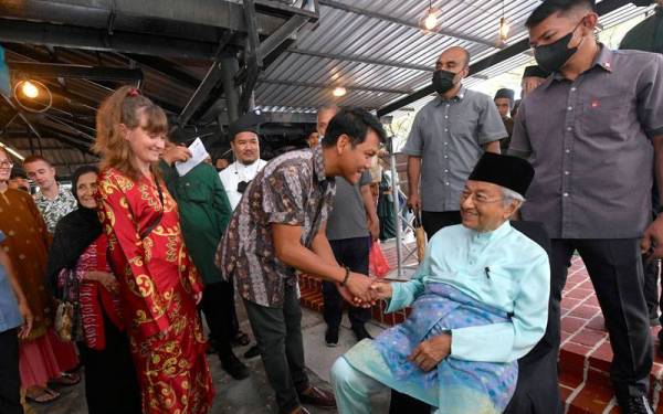 Pelancong asing tidak melepaskan peluang bertemu dan mengucapkan hari raya kepada Dr Mahathir pada Majlis Jamuan Hari Raya Parlimen Langkawi di Dataran Telaga Walk dekat Pantai Chenang pada Isnin. - Foto Bernama