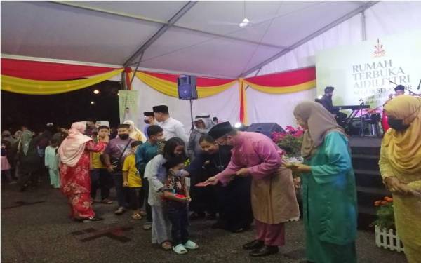 Amirudin menyampaikan sumbangan duit raya kepada kanak-kanak yang hadir pada Rumah Terbuka Aidilfitri Negeri Selangor Peringkat Gombak di Tapak Bazar Ramadan Taman Melawati, pada Isnin.