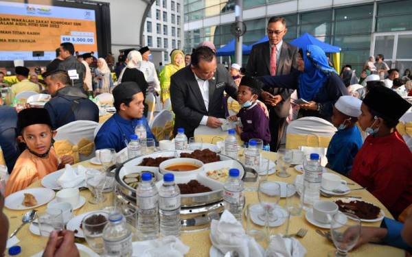 Nanta bersama Timbalan Menteri Perdagangan Dalam Negeri dan Hal Ehwal Pengguna, Datuk Rosol Wahid menyampaikan sumbangan duit raya kepada anak-anak yatim ketika Majlis Salam Aidilfitri SSM 2022 di Anjung Sentral Menara SSM pada Selasa. - Foto Bernama