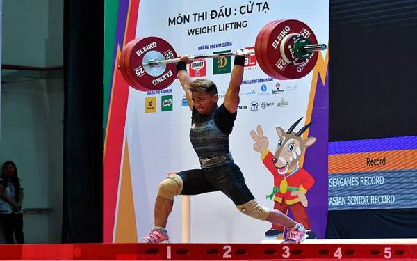 Aniq Kasdan beraksi dalam acara snatch, clean and jerk 55kg lelaki pada Sukan SEA Hanoi 2021 di Hanoi Sports Training Centre pada Khamis. Foto: Bernama