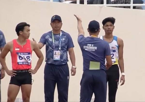 Muhammad Azeem diarahkan pegawai pertandingan meninggalkan trek selepas melakukan 'false start' separuh akhir acara 100m lelaki Sukan SEA Hanoi 2021 di Vietnam pada Rabu.