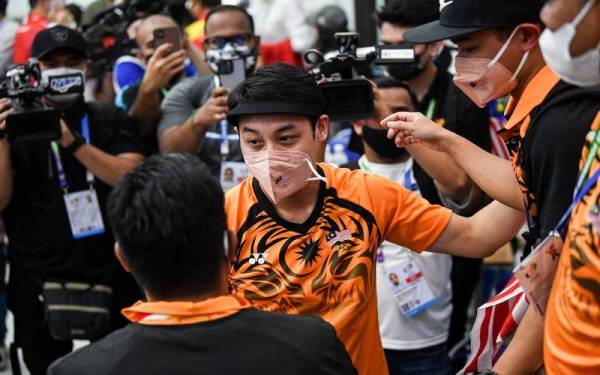 Johnathan menerima ucapan tahniah daripada pegawai kontinjen Malaysia selepas meraih emas acara 10m air pistol di Pusat Latihan Sukan Nasional, Hanoi pada Khamis. - Foto Bernama