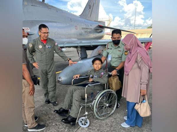 Muhammad Irfan Mikael (duduk) ketika dibawa meninjau pesawat Hawk 108 dan F18 Hornet.
