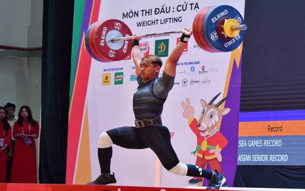 Muhammad Erry melakukan angkatan dalam acara 73 kilogram snatch, clean and jerk pada Sukan SEA ke-31 pada Sabtu. - Foto Bernama