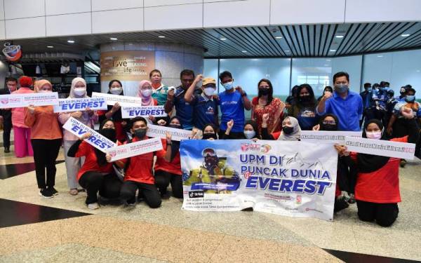 Pendaki Everest yang berjaya mendaki gunung tersebut kali ketiga T. Ravichandran (belakang kanan,empat) bergambar bersama pelajar pelajar Universiti Putra Malaysia (UPM) sejurus tiba di Lapangan Terbang Antarabangsa Kuala Lumpur, pada Ahad. - Foto Bernama