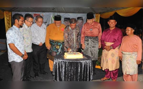 Mat Sabu (tengah) memotong kek pada Majlis Sambutan Hari Raya Aidilfitri Parti Amanah Johor di Kempas, Johor Bahru pada malam Sabtu.