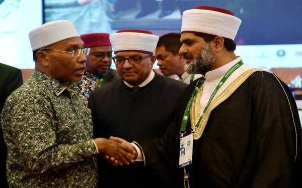 Idris (kiri) bersalaman dengan Pengarah dan Imam Masjidil Aqsa, Sheikh Omar Fahmi Awadallah Al-Kiswani (kanan) pada Majlis Penutup Sidang Kemuncak Ulama 2022 Perpaduan Asas Pembebasan Al-Aqsa pada Ahad. - Foto Bernama *** Local Caption ***