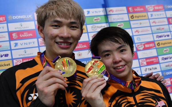 Pemain badminton negara Chen Tang Jie (kiri) dan Peck Yen Wei bersama pingat emas yang dimenangi mereka dalam acara akhir beregu campuran pada Sukan SEA ke-31, hari ini. - Foto Bernama