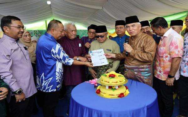 Bung Moktar dan Dr Yusof (dua dari kanan) menyaksikan penyerahan borang ahli UMNO bagi mereka yang ingin menyertai UMNO ketika hadir pada Majlis Ramah Mesra Aidilfitri beliau di Kampung Palakat, Sipitang.