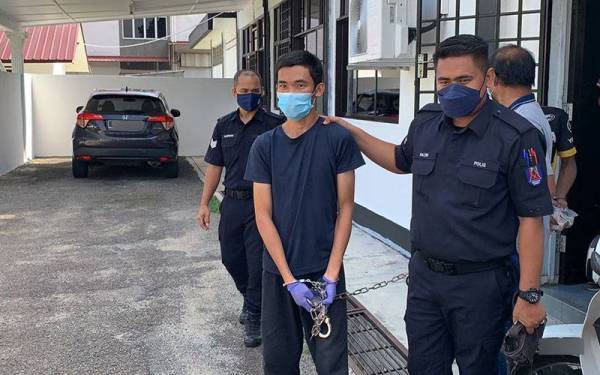 Gabriele Jungkak (kiri) dibawa anggota polis ke kamar perbicaraan Mahkamah Majistret Kulai pada Isnin.