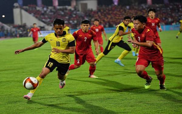 Pemain negara Malaysia, Luqman Hakim Shamsudin (kiri) mengawal bola ketika menentang pasukan Vietnam pada saingan Sukan SEA 2021 di Stadium Viet Tri. - Foto Bernama