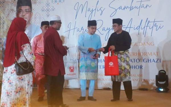 Khaled Nordin (dua dari kiri) dan Onn Hafiz (tengah) menyerahkan sumbangan kepada bakal haji ketika Majlis Hari Raya Aidilfitri UMNO Bahagian Pasir Gudang di Dewan Puncak Kasih, Bukit Layang-Layang, Pasir Gudang pada malam Isnin.