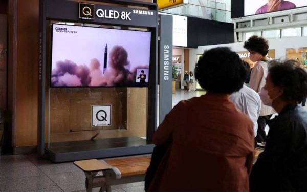 Orang ramai menonton televisyen yang menyiarkan laporan berita mengenai pelancaran tiga peluru berpandu Korea Utara di Seoul, Korea Selatan. - Foto Reuters
