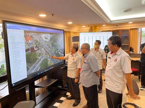 Anwar (kiri) melihat CCTV di kawasan lokasi hotspot banjir.