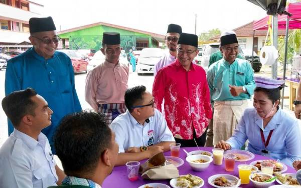 Timbalan Menteri Kesihatan Datuk Dr Noor Azmi Ghazali meraikan beberapa kakitangan kesihatan dan guru pada majjis Jamuan Hari Raya Aidilfitri dan RIMUP di Sekolah Kebangsaan Kuala Gula, pada Khamis. - Foto Bernama