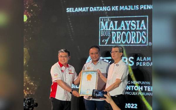 Hock San (kanan) menerima sijil Malaysia Book of Records (MBOR) daripada Christopher (kiri) sambil disaksikan Reezal Merican pada Majlis Pengiktirafan MBOR-LBS di KITA@Cybersouth pada Khamis.