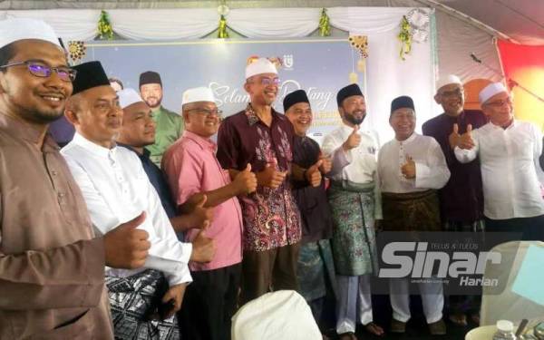 Mukhriz (empat dari kanan) meraikan pemimpin setempat dari pelbagai parti politik yang hadir pada Majlis Rumah Terbuka Aidilfitri AhIi Parlimen Jerlun di Dataran Sungai Korok pada Jumaat.