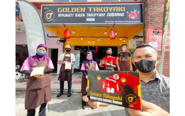 Haz Syafi eq (kanan) bersama pekerja di hadapan Restoran Golden Takoyaki miliknya di Sungai Kapar Indah, Kapar.