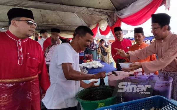 Zahidi (dua kanan) mencuba rojak buah di sebuah gerai pada Majlis Ramah Mesra Hari Raya Aidilfitri Timbalan Menteri Komunikasi dan Multimedia di Padang Majlis Perbandaran Sungai Petani Kedah (MPSPK) di Ambangan Height, Sungai Petani pada Sabtu.