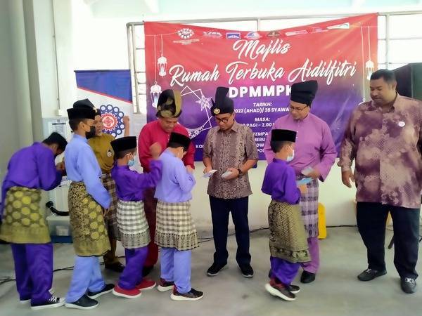 Zainol Fadzi (dua dari kiri) menyampaikan sumbangan duit raya kepada anak-anak yang hadir ke Majlis Rumah Terbuka Aidilfitri DPPM Perak di Lobi Residences DWJ@Meru pada Ahad.