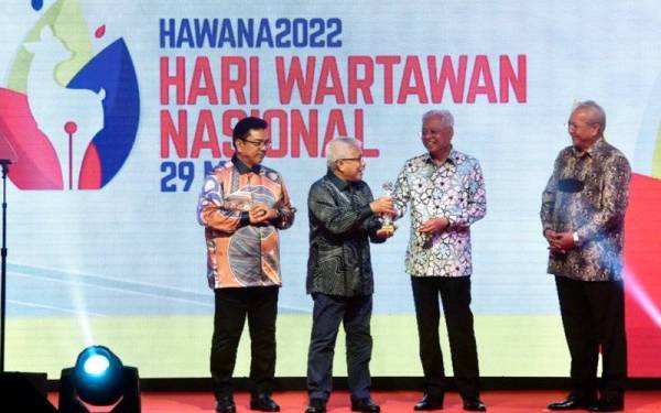 Ismail Sabri (dua kanan) menyampaikan Anugerah Hari Wartawan Nasional (Hawana) 2022 bernilai RM10,000 kepada Hussamuddin (dua, kiri) ketika hadir pada Majlis Kemuncak Hawana 2022 di Hotel Hatten pada Ahad. - Foto Bernama
