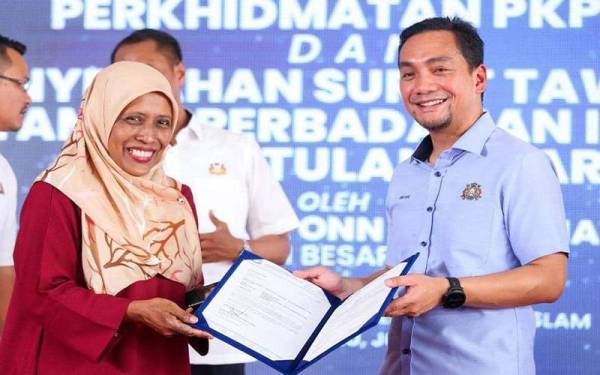 Onn Hafiz (kanan) menyampaikan surat tawaran memiliki kediaman di Taman Perbadanan Islam (TPI) Stulang Baru kepada salah sorang penerima.