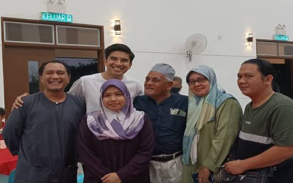 Syed Saddiq merakam kenangan bersama ahli parti dan tetamu yang hadir ke majlis Rumah Terbuka DUN Puteri Wangsa Bersama Muda Johor di Taman Setia Indah, Johor Bahru, pada malam Ahad.