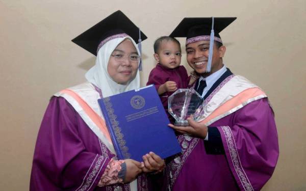 Pasangan suami isteri Abdul Aziz Ahmad, 27, dan isteri Ilham Md Nazan, 26, menerima Ijazah Sarjana Muda Bahasa Arab sambil mendukung bayi mereka Ahmad Abdul Aziz yang berusia 15 bulan pada Majlis Istiadat Konvokesyen Khas (gantian Istiadat Konvokesyen kali ke-22) Universiti Islam Antarabangsa Sultan Abdul Halim Mu'adzam Shah (UniSHAMS) di Kuala Ketil, pada Isnin.- Foto Bernama
