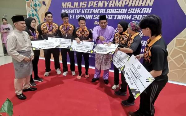 Khairul Shahril (empat dari kanan) beramah mesra dengan atlet Perak yang mendapat pingat pada Majlis Penyampaian Insentif Kecemerlangan Sukan Atlet Sukan SEA Vietnam 2021 dan Majlis Rumah Terbuka Aidilfitri Majlis Sukan Negeri Perak di Dewan Wisma MSN Perak, Ipoh pada Isnin.