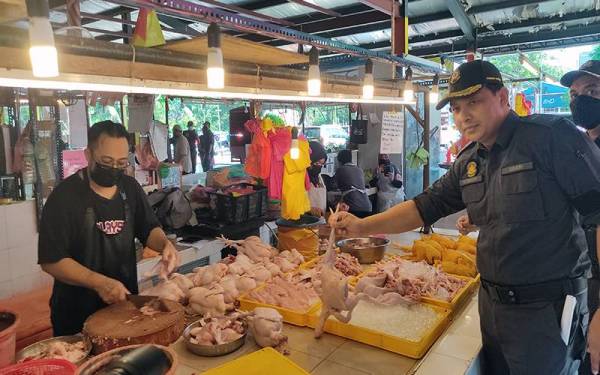 Mohd Khairi (kanan) ketika melawat sebuah gerai menjual ayam di Pasar Moden Seksyen 16, di sini pada Selasa.