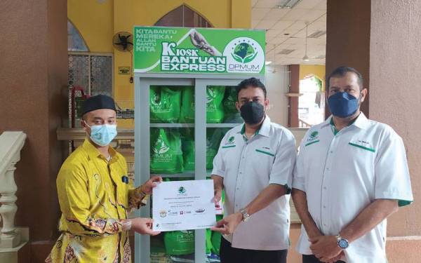 Muhammed Ismail (dua dari kanan) menyampaikan bekalan makanan kepada wakil masjid bagi projek Kiosk Bantuan Ekspress DPMUM.