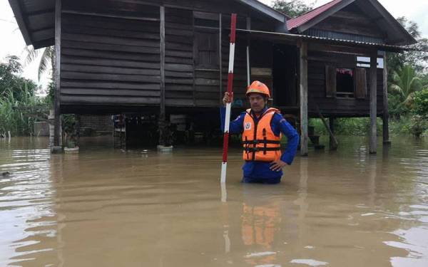 Anggota APM Pendang memantau paras air di kawasan Pendang yang dilanda banjir pada Jumaat.