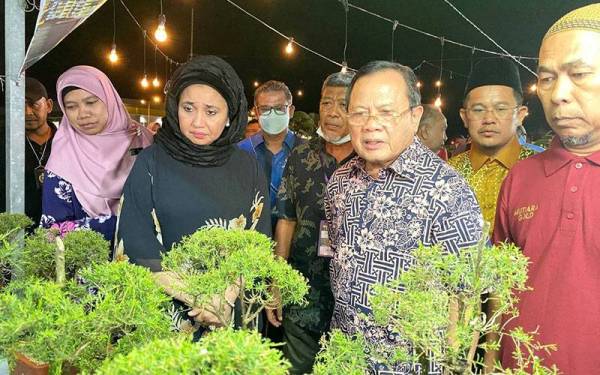 Ahmad (dua dari kanan) melawat gerai pameran selepas merasmikan Pesta Orkid, Flora dan Herba 2022 di Pusat Transformasi Luar Bandar Tunjung, Kota Bharu pada Jumaat.