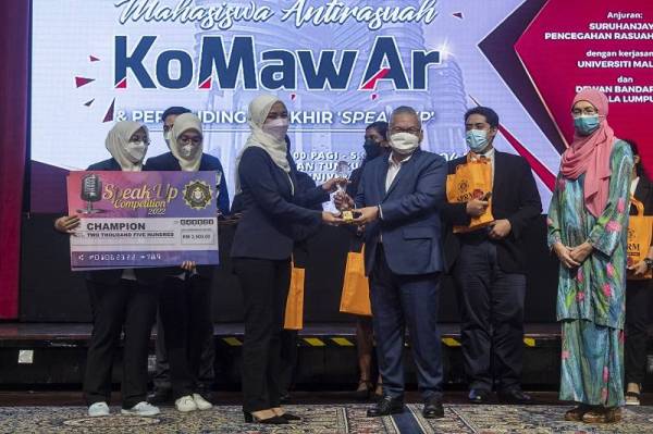 Norazlan menyampaikan trofi pemenang pertandingan 'Speak Up' kepada pelajar Kolej Poly-Tech Mara, Madiha Syahidah Mohd Rohani pada Majlis Konvensyen Mahasiswa Antirasuah dan Pertandingan Akhir 'Speak Up' di Dewan Tunku Canselor Universiti Malaya pada Sabtu. - Foto Bernama