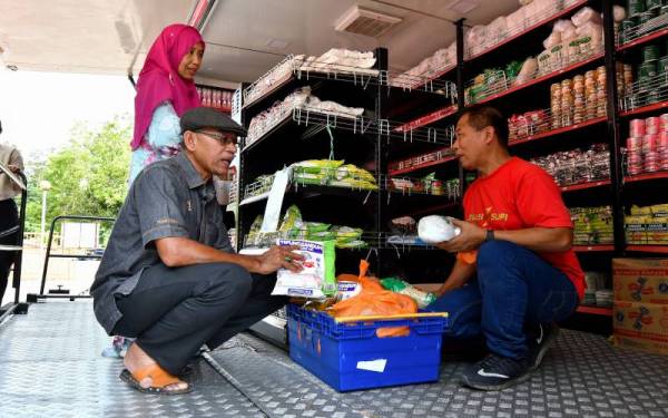 Timbalan Menteri Perdagangan Dalam Negeri dan Hal Ehwal Pengguna Datuk Rosol Wahid (kiri) meninjau tepung gandum yang dijual semasa Program Jualan Kedai Prihatin di Kampung Gaung, Hulu Terengganu, pada Ahad. - Foto Bernama