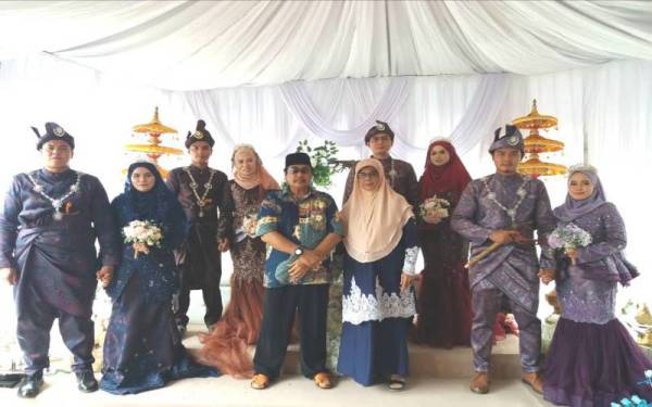 Subhi (tengah) dan Rohani bersama empat pengantin itu pada majlis persandingan anaknya di Felda Bukit Cherakah 2, Kapar pada Ahad.