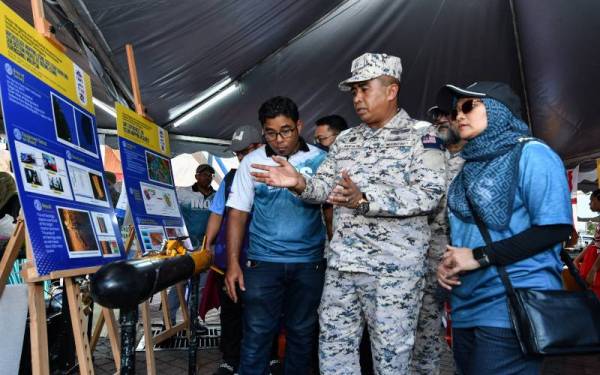 Saiful Lizan (dua dari kanan) melawat ruang pameran selepas melancarkan Hari Kesedaran Keselamatan Maritim dan 'World Ocean Week' di Pantai Batu Buruk. - Foto Bernama