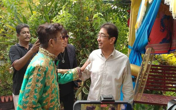 Zahidi (kanan) bertemu M Daud Kilau ketika Program Ziarah Kasih ke kediaman penyanyi veteran, itu di Kampung Sungai Balai Baroh, di sini pada Selasa.