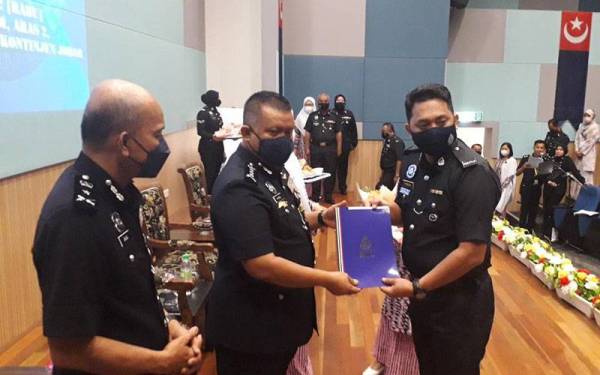 Kamarul Zaman (tengah) menyampaikan sijil kepada penerima pada Majlis Pemakaian Pangkat Rendah Polis Kontinjen Johor sesi 2/2022 di IPK Johor pada Rabu.