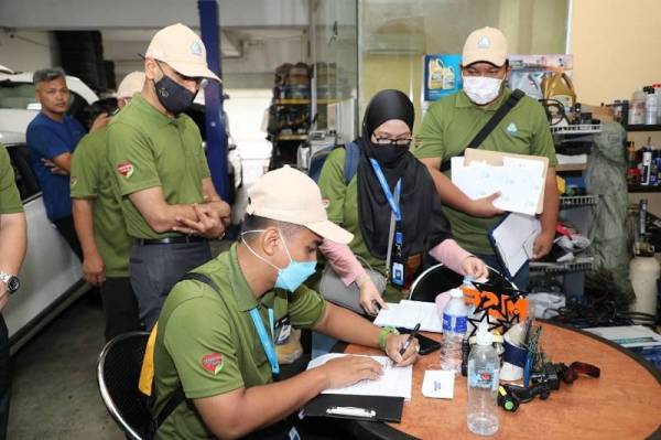 Mohammed Azman (kiri) ketika melakukan pemantauan di beberapa premis di Dataran Otomobil, Seksyen 15 pada Rabu.