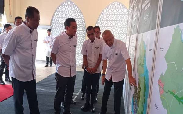 Datuk Bandar Pasir Gudang, Datuk Asman Shah Abd Rahman (kanan) memberi penerangan ringkas mengenai RTPG 2030 kepada Onn Hafiz (tengah) pada Program Publisiti dan Penyertaan Awam RTPG di Menara Aqabah, Pasir Gudang pada Khamis.