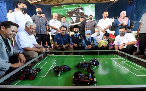 Menteri Kanan Pendidikan Datuk Dr Mohd Radzi Md Jidin meluangkan masa mencuba permainan robot bersama beberapa pelajar selepas melancarkan Felda Digital Maker Hub Coding & Robotic di Sekolah Kebangsaan Sahabat 4, pada Sabtu. Hadir sama, Pengerusi Lembaga Kemajuan Tanah Persekutuan (Felda) Tan Sri Idris Jusoh (dua, kiri). - Foto Bernama
